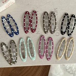 Détail de diverses pinces à cheveux BB elliptiques à pois colorés en paires pour coiffer