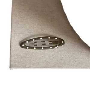 Barrette à cheveux ovale style coréen vert olive à pois blancs sur fond en tissu