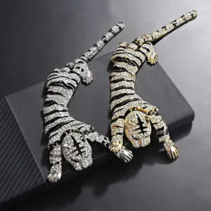 Close-up of luxury gold and silver tiger brooches with sparkling crystal details.