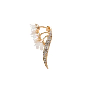 Elegant lily of the valley brooch with pearls and sparkling rhinestones on gold base