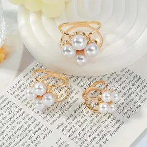 Detailed view of elegant hollow gold alloy scarf clips with white pearl cluster design