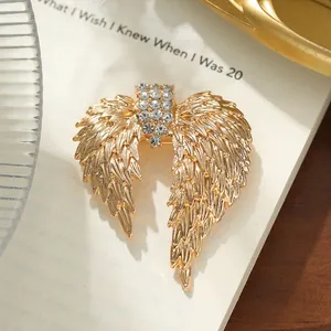 Close-up of vintage golden wing brooch with intricate feather details and rhinestones