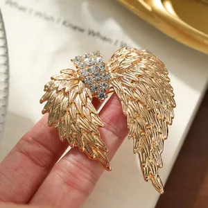 Detailed view of a vintage gold alloy angel wing brooch with sparkling rhinestones