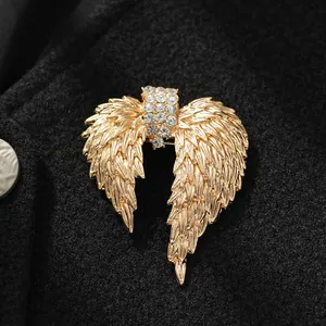 Close-up of a vintage golden wing brooch featuring shimmering rhinestone center details.