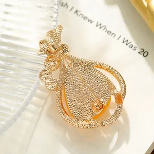 Detailed back view of a refined golden alloy gourd brooch with honeycombed texture finish