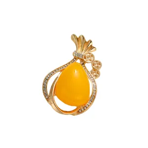 Elegant gold alloy brooch featuring a yellow teardrop resin stone and crystal accents