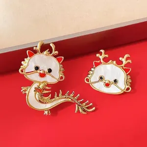 Set aus niedlichen goldfarbenen Drachen-Broschen mit weißem Emaille auf rotem Grund.