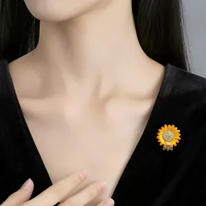 Detailed view of an elegant yellow alloy daisy brooch with rhinestones on black fabric