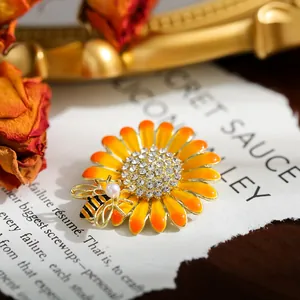 Close-up of elegant sunflower brooch with rhinestone center and pearl bee detail
