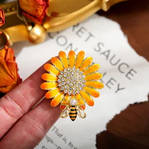 Close-up of yellow daisy brooch with sparkling rhinestones and a small bee detail