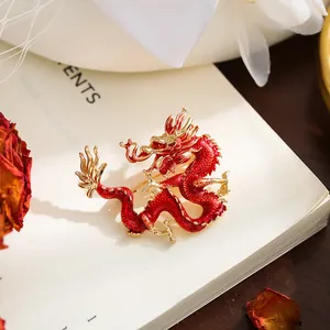 Detalle macro de un broche de dragón chino en esmalte rojo y aleación chapada en oro