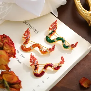 Close-up detail of three colorful dragon enamel brooches with sparkling crystal accents