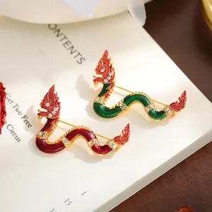 Detailed close-up of vibrant red and green dragon brooches with sparkling crystal accents.