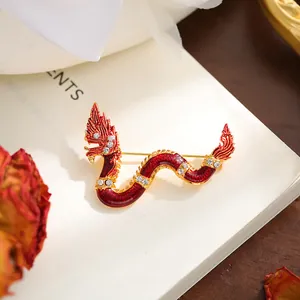Close-up detail of an elegant red and gold dragon brooch with sparkling rhinestones on a book