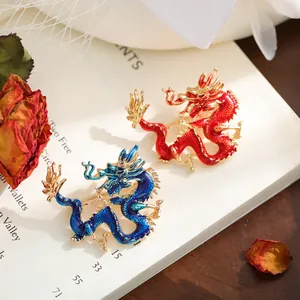 Primer plano de broches de dragón de esmalte en rojo y azul con elegante chapado en oro