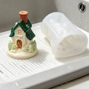 Close-up detail view of white silicone mold and a finished Christmas house resin ornament