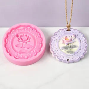 Ronde siliconen mal met lotusbloem naast een afgewerkte aromatherapie gipshanger
