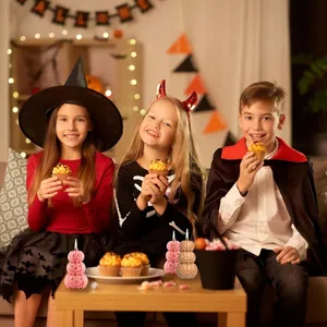 Detailed view of 3-tier pumpkin candles at a Halloween party used as decorations