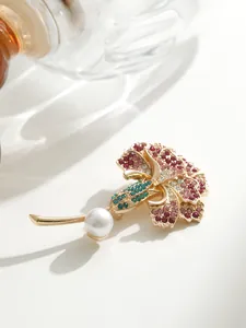 Détail rapproché de l'élégante broche œillet avec strass roses et perle blanche