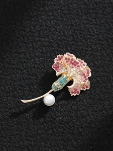 Détail macro d'une broche œillet élégante avec strass colorés et une perle blanche fine