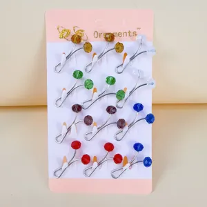 Close-up of a set of twelve colorful crystal bead U-shaped scarf pins on a display card.