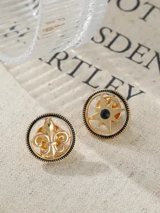 Detailed close-up of vintage gold fleur-de-lis and star lapel pins for men's suits