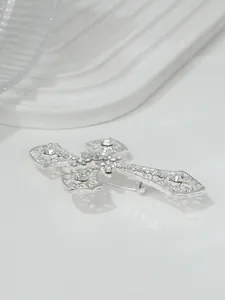 Detaillierte Nahaufnahme einer eleganten silbernen Kreuzbrosche mit Strassbesatz