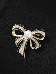 Detailansicht einer eleganten Schleifenbrosche mit schwarzer Emaille, Strass und Perle
