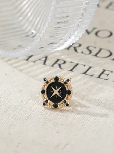 Close-up of vintage gold brooch with twisted root pattern and star motif