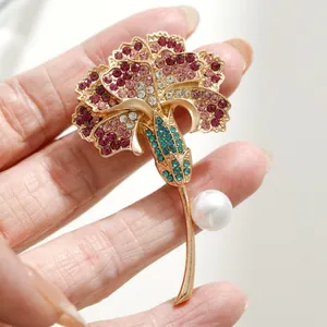 Broche élégante en forme d'oeillet avec strass roses et perle d'imitation