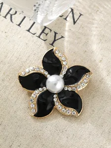 Exquisite Nahaufnahme einer schwarzen Emaille-Kamelienbrosche mit Goldrand und Perle