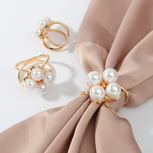 Elegant golden hollow scarf buckle set featuring four-pearl clover design on silk scarf.