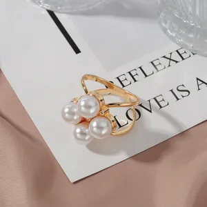 Elegant gold scarf ring with pearl cluster on silk background
