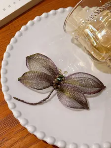 Gedetailleerd overzicht van een elegante handgemaakte paarse libelle broche van gaas