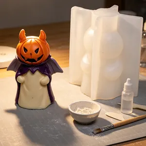 Detail of Halloween pumpkin ghost candle mold with finished resin figure and tools