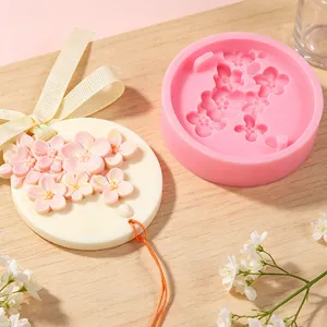 Close-up of embossed cherry blossom silicone mold and finished plaster aromatherapy hanging
