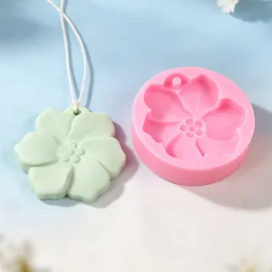 Detailansicht einer rosa Kirschblüten-Silikonform neben einem grünen Blumenanhänger