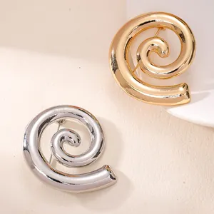 Detailansicht goldener und silberner Spiral-Broschen für elegantes Anzug-Styling