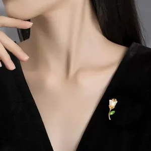 Detailansicht einer eleganten Blumenbrosche mit weißen Muschelblättern auf schwarzem Samt.