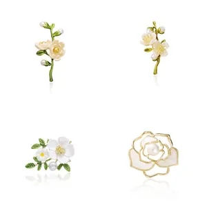 Elegante Broschen-Kollektion mit Perlen und Blumen auf weißem Hintergrund.