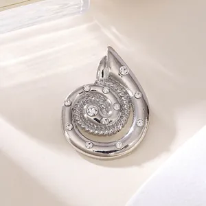 Makroansicht einer eleganten silbernen Spiralbrosche mit funkelnden Strasssteinakzenten