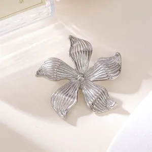 Nahaufnahme einer eleganten silbernen Blumenbrosche mit strukturierten Blüten
