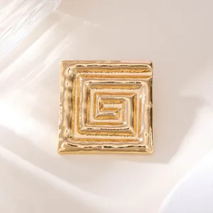 Nahaufnahme einer luxuriösen goldenen quadratischen Brosche mit griechischem Muster