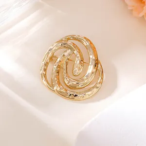 Nahaufnahme einer hochwertigen goldenen gehämmerten Spiralbrosche für elegante Anzüge