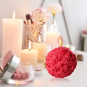 Nahaufnahme einer roten Rosenkugel-Duftkerze mit eleganten Blumenschnitzereien