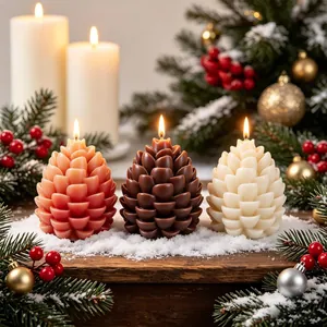 Gedetailleerd overzicht van drie decoratieve dennenappelkaarsen in kerstthema.