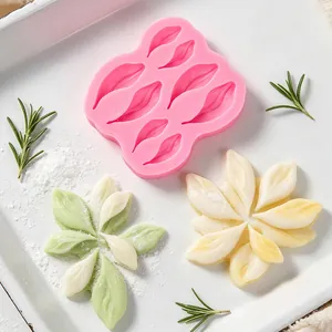 Detailed view of pink silicone flower petal mold with finished fondant decorations.