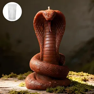 Intricate cobra snake silicone mold shown with a finished brown candle on a mossy base
