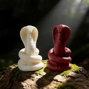 Detailed shot of cobra snake ornaments in white and red set on mossy wood in sunlight