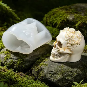 Detailed view of rose skull silicone mold and finished plaster craft on mossy rock surface